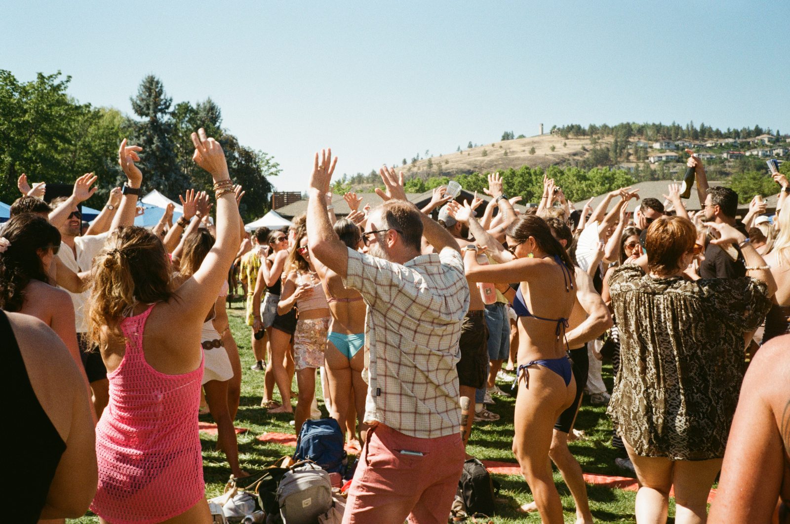 Women dancing with hands raised in bright sun