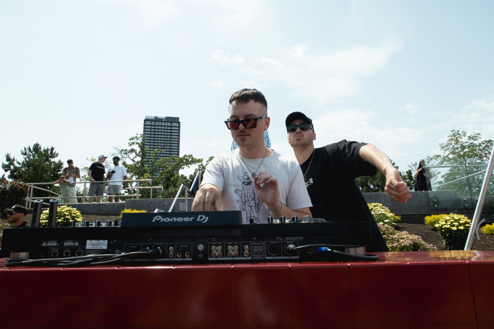 Two DJs in sunglasses behind the decks